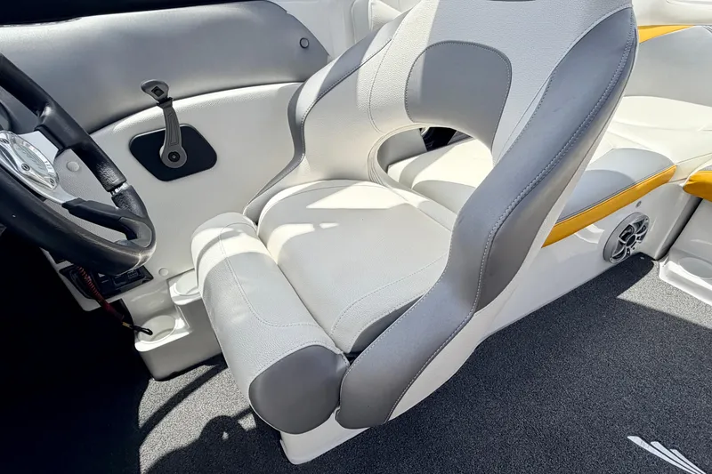 Slide: The Image of 2014 Tigé R20 boat interior with gray and white seating, steering wheel, and speaker. - 52