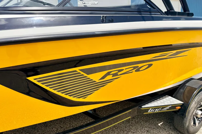 Slide: The Image of Yellow 2014 Tigé R20 boat with black detailing on a trailer. - 11