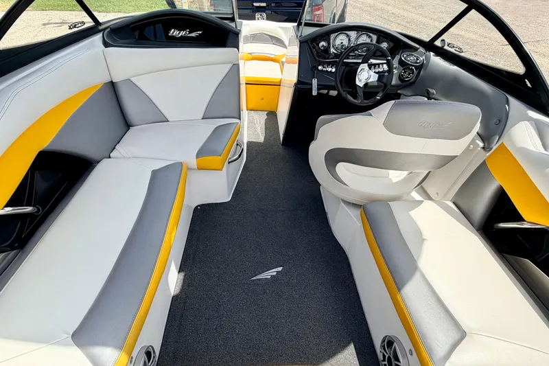 Slide: The Image of 2014 Tigé R20 boat interior with gray and yellow seating, modern dashboard, and steering wheel. - 54