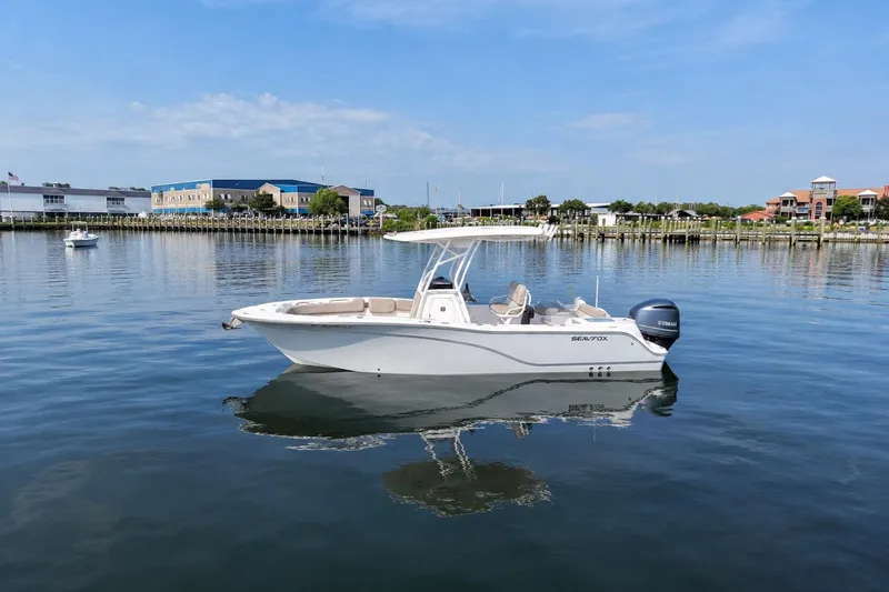 Slide: The Image of 2022 Sea Fox 248 Commander boat on calm water near a marina. - 1