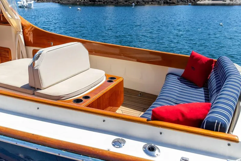 Slide: The Image of Hinckley Picnic Boat 36 Classic 2000 with elegant seating, striped cushions, and scenic water view. - 11