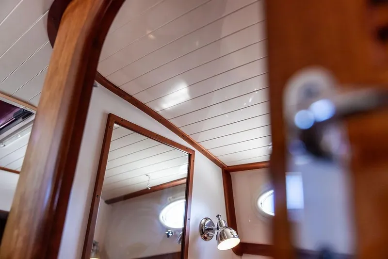 Slide: The Image of Interior of 2000 Hinckley Picnic Boat 36 Classic with wood paneling and porthole window. - 17