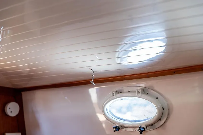 Slide: The Image of Interior view of 2000 Hinckley Picnic Boat 36 Classic with porthole and wooden trim. - 19