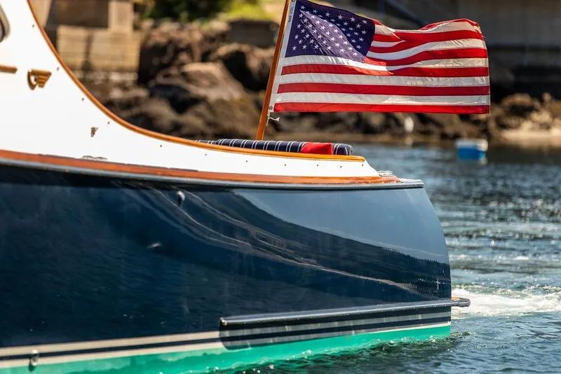 Slide: The Image of Hinckley Picnic Boat 36 Classic (2000) with American flag on water. - 3