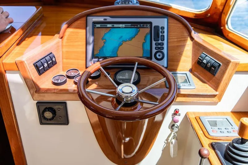 Slide: The Image of Hinckley Picnic Boat 36 Classic 2000 helm with wooden steering wheel and navigation display. - 4