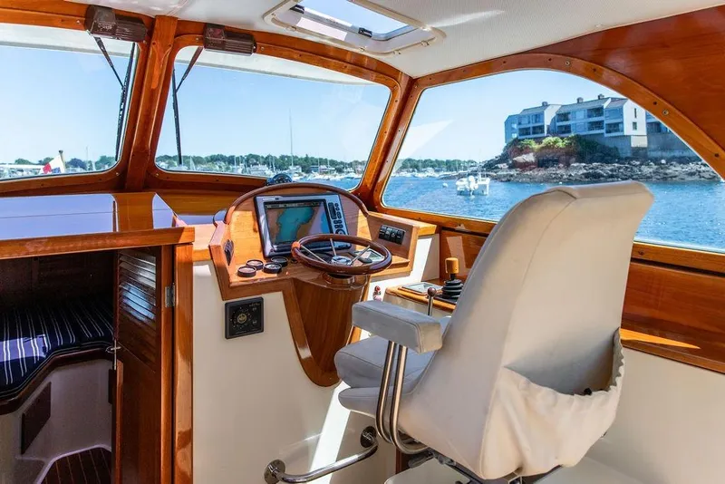 Slide: The Image of Interior of 2000 Hinckley Picnic Boat 36 Classic with wooden dashboard and scenic water view. - 5