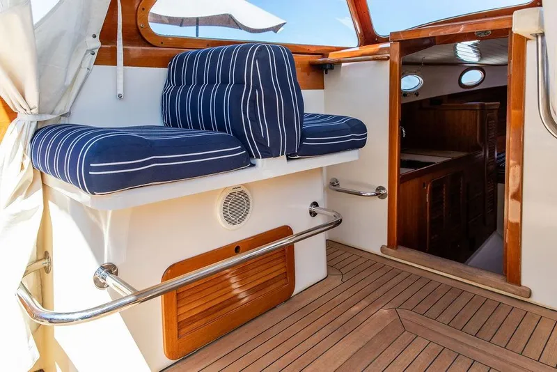 Slide: The Image of Hinckley Picnic Boat 36 Classic 2000 interior with striped cushions and wooden accents. - 7