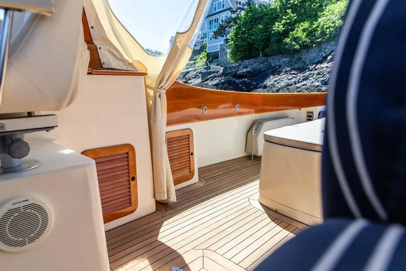 Slide: The Image of Interior of 2000 Hinckley Picnic Boat 36 Classic with wooden deck and coastal view. - 8