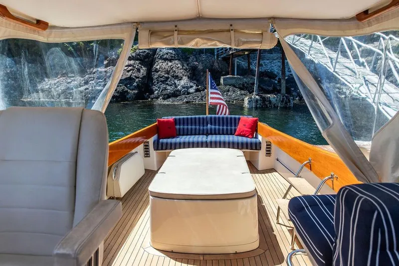 Slide: The Image of Interior of 2000 Hinckley Picnic Boat 36 Classic with striped seating and American flag. - 9