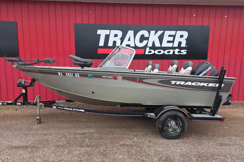 Slide: The Image of 2005 Tracker Pro Guide V-16 WT boat on trailer, parked by red building. - 6