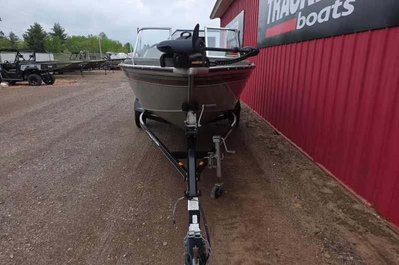 Slide: The Image of 2005 Tracker Pro Guide V-16 WT boat on trailer beside red building. - 7