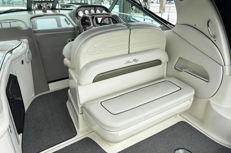 Slide: The Image of Interior of a 2006 Sea Ray 300 Sundancer boat with white seating and dashboard. - 12