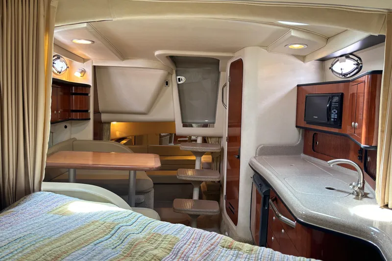 Slide: The Image of Interior of 2006 Sea Ray 300 Sundancer yacht with kitchenette and dining area. - 18