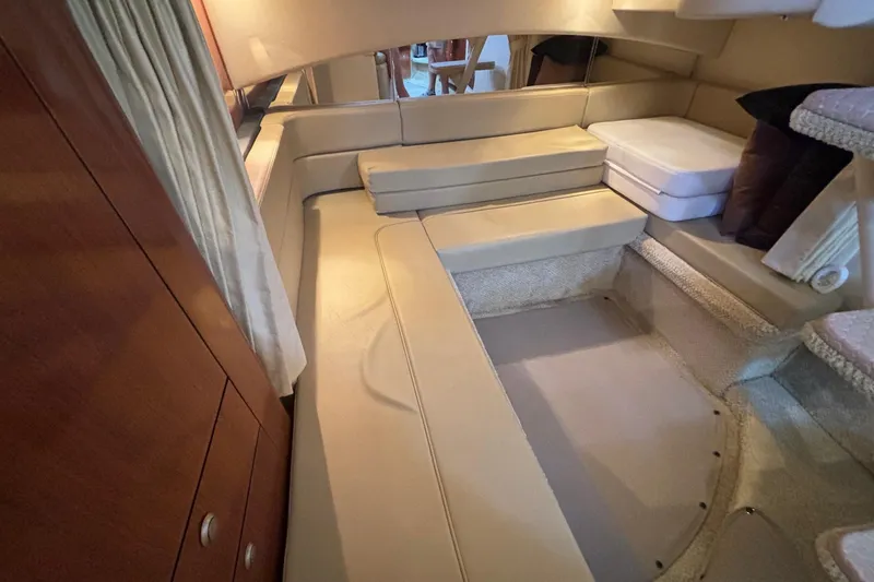 Slide: The Image of Interior cabin of 2006 Sea Ray 300 Sundancer with beige seating and wooden cabinetry. - 21