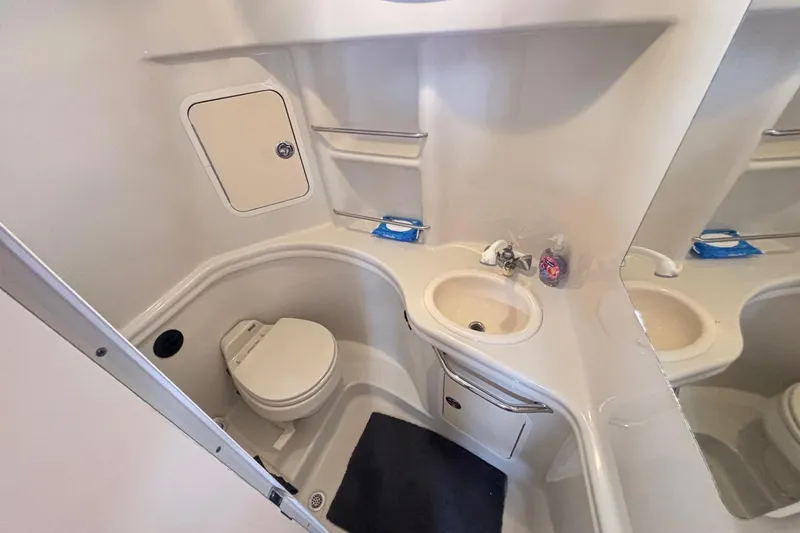 Slide: The Image of 2006 Sea Ray 300 Sundancer bathroom with toilet, sink, and storage cabinet. - 22