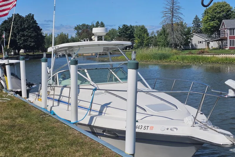 Slide: The Image of 1998 Pro-Line 3250 Express boat docked by a scenic riverside. - 1