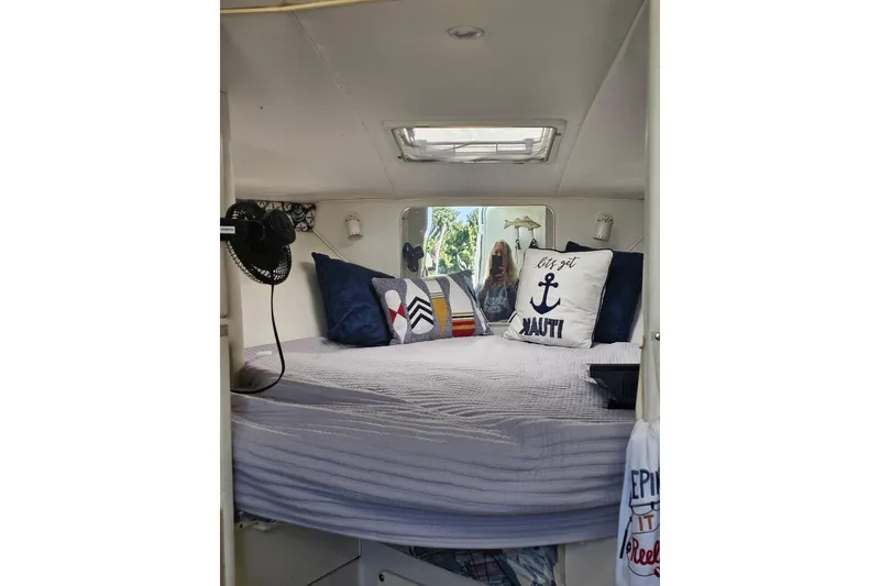 Slide: The Image of Cozy cabin interior of 1998 Pro-Line 3250 Express with nautical-themed pillows and bedding. - 10