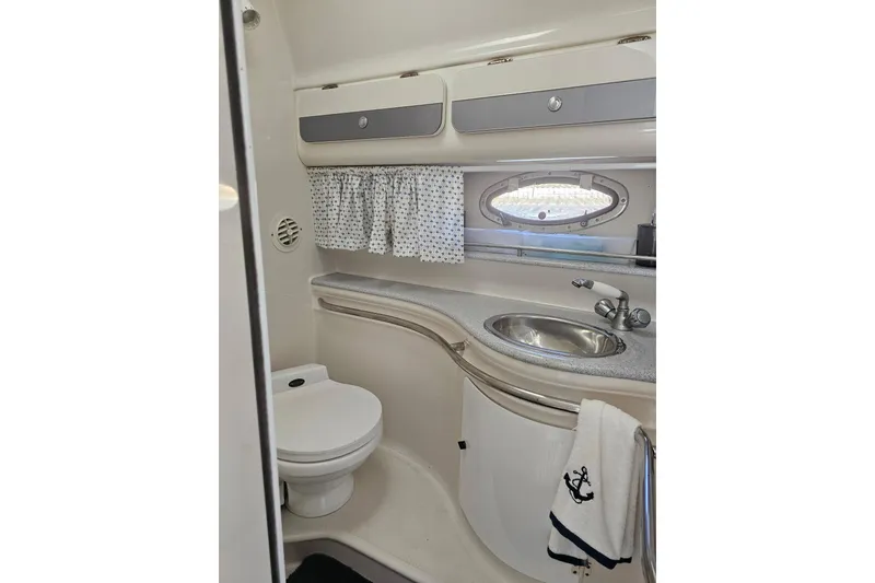 Slide: The Image of 1998 Pro-Line 3250 Express boat bathroom with sink, toilet, and porthole window. - 11
