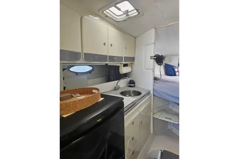 Slide: The Image of 1998 Pro-Line 3250 Express cabin interior with kitchenette and sleeping area. - 8