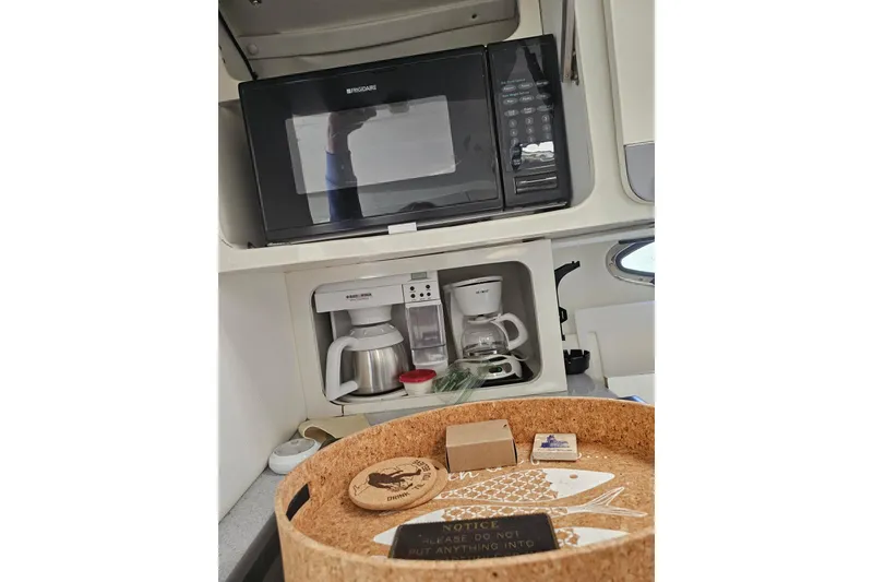 Slide: The Image of 1998 Pro-Line 3250 Express boat kitchen with microwave and coffee maker setup. - 9