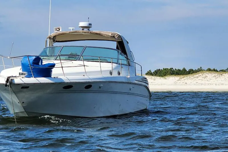 Slide: The Image of 1998 Sea Ray Sundancer 400 yacht anchored near sandy beach, clear blue sky. - 3