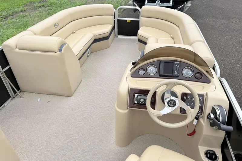 Slide: The Image of 2013 South Bay 522CR pontoon boat interior with beige seating and modern dashboard. - 4