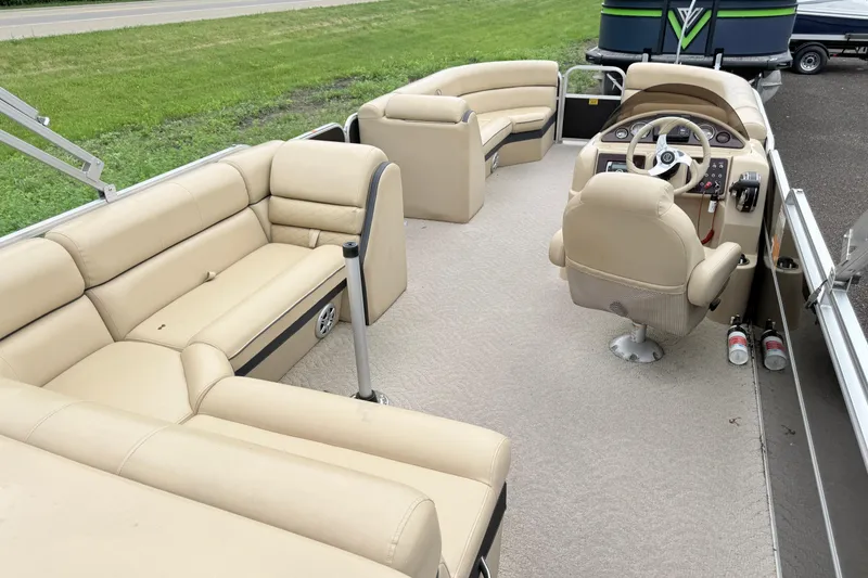 Slide: The Image of 2013 South Bay 522CR pontoon boat interior with beige seating and steering console. - 5