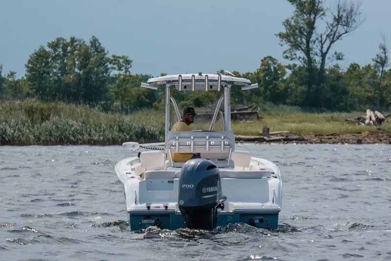 Slide: The Image of 2022 Sea Hunt Ultra 229 boat cruising on a lake with trees in the background. - 6