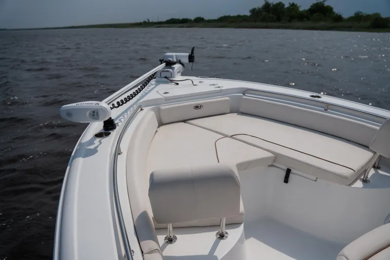 Slide: The Image of 2022 Sea Hunt Ultra 229 boat with spacious seating on calm waters. - 13