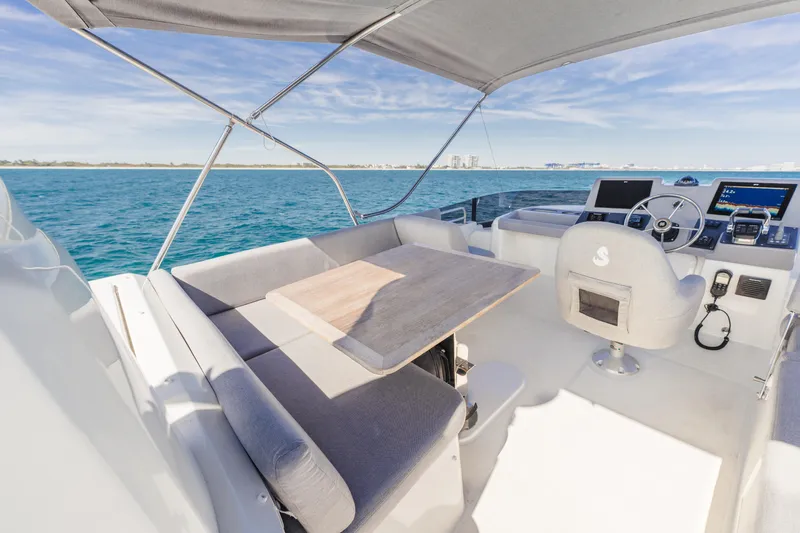 Slide: The Image of 2025 Beneteau Swift Trawler 41 Fly bridge with seating and helm, overlooking ocean. - 10