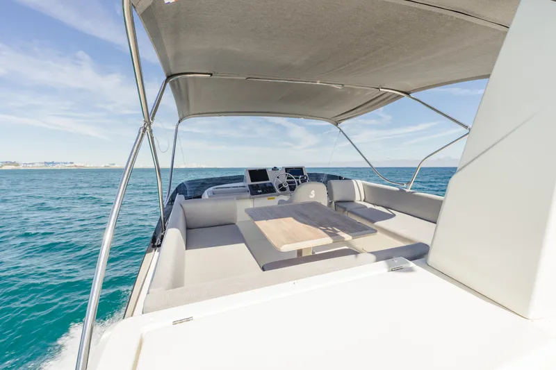 Slide: The Image of 2025 Beneteau Swift Trawler 41 Flybridge with seating, table, and ocean view. - 13