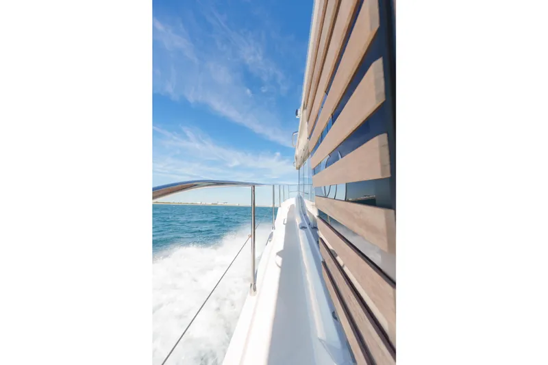 Slide: The Image of 2025 Beneteau Swift Trawler 41 Fly cruising on open water under clear blue sky. - 18