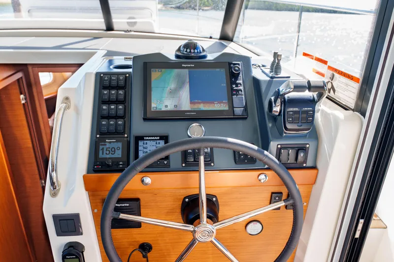 Slide: The Image of Helm of 2025 Beneteau Swift Trawler 41 Fly with navigation equipment and steering wheel. - 31