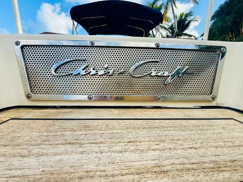Slide: The Image of 2015 Chris-Craft Launch 32 boat logo on wooden deck, tropical background. - 16