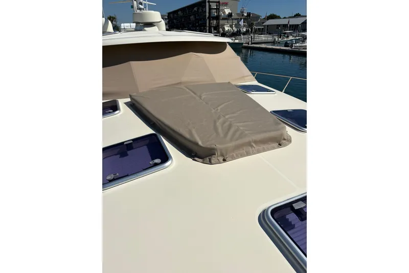 Slide: The Image of 2018 Palm Beach Motor Yachts 55 deck with covered hatch, docked at marina. - 18