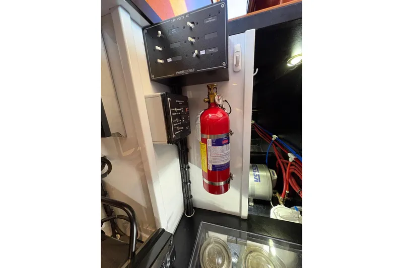 Slide: The Image of Engine room of 2018 Palm Beach Motor Yachts 55 with fire extinguisher and control panels. - 43