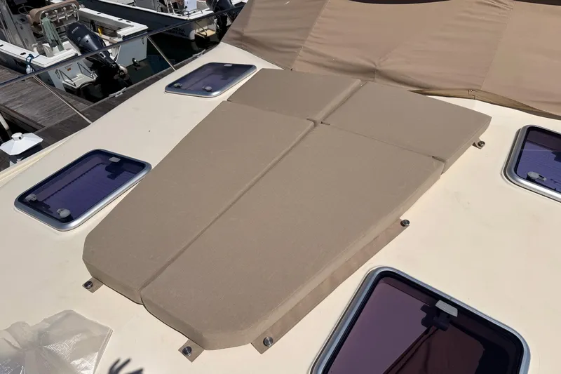 Slide: The Image of Sunpad on 2018 Palm Beach Motor Yachts 55, featuring beige cushions and deck hatches. - 15