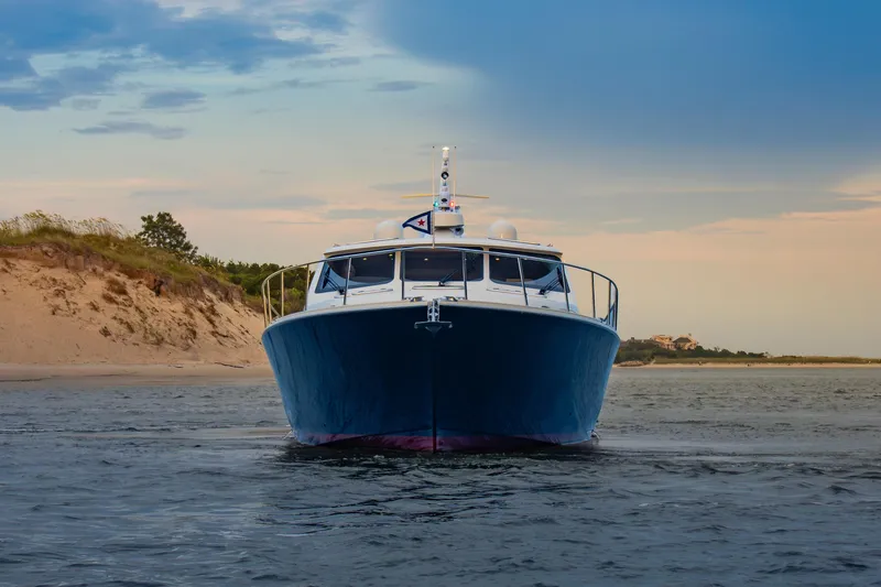 Slide: The Image of 2018 Palm Beach Motor Yachts 55 cruising near sandy shoreline at sunset. - 3