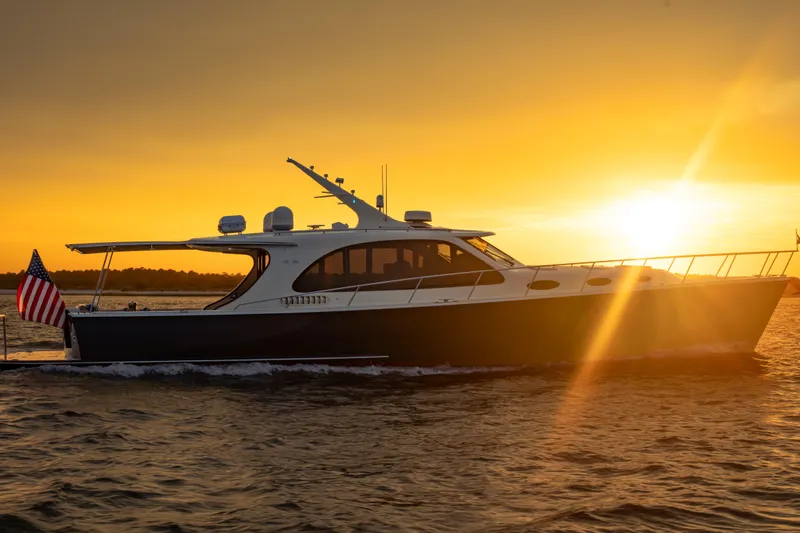 The Image of 2018 Palm Beach Motor Yachts 55 cruising at sunset with American flag. - 0