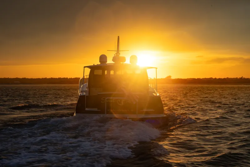Slide: The Image of 2018 Palm Beach Motor Yachts 55 cruising at sunset on open water. - 10