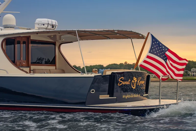 Slide: The Image of 2018 Palm Beach Motor Yachts 55 cruising with American flag at sunset. - 9