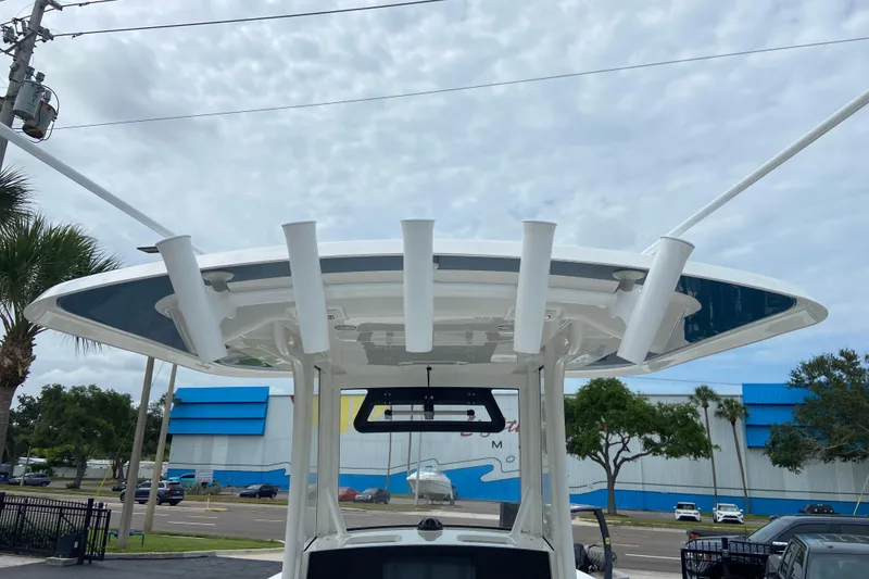 Slide: The Image of 2027 Regulator 26XO boat with rod holders and T-top against a cloudy sky. - 13