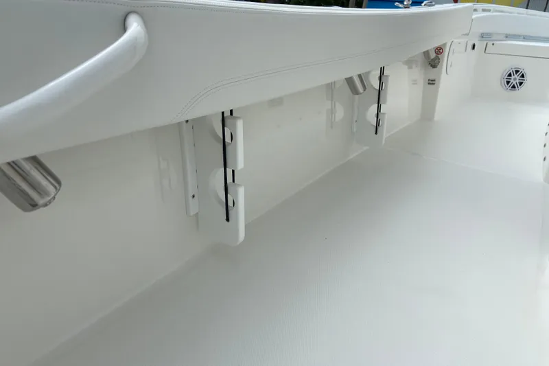 Slide: The Image of 2027 Regulator 26XO boat interior, featuring sleek white design and rod holders. - 16