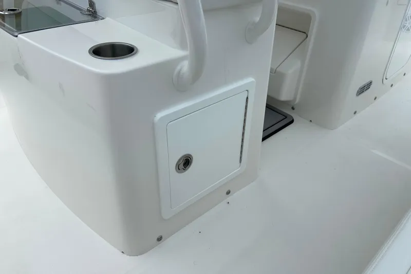 Slide: The Image of 2027 Regulator 26XO boat interior with storage compartment and cup holder. - 19