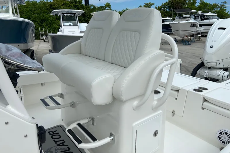 Slide: The Image of 2027 Regulator 26XO boat with white cushioned seating and dual footrests. - 23