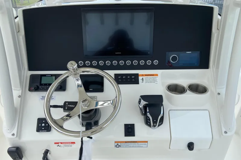 Slide: The Image of 2027 Regulator 26XO boat dashboard with steering wheel, controls, and electronic displays. - 26