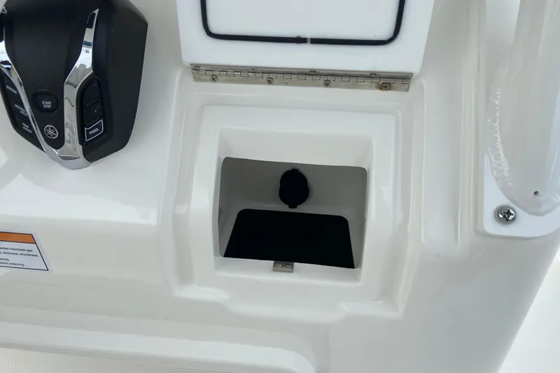 Slide: The Image of Control panel of 2027 Regulator 26XO boat with throttle and storage compartment. - 32