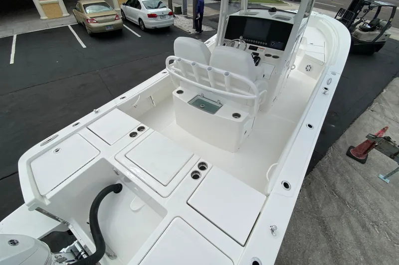 Slide: The Image of 2027 Regulator 26XO boat interior with dual seats and control panel in a parking lot. - 4