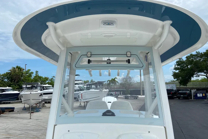 Slide: The Image of 2027 Regulator 26XO boat with T-top, docked among other vessels. - 40