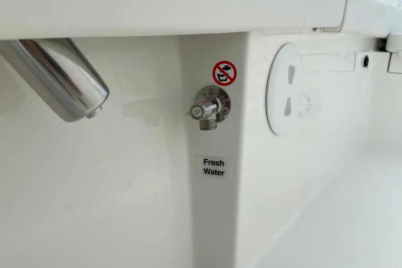 Slide: The Image of Fresh water outlet on 2027 Regulator 26XO boat, featuring a no-smoking sign. - 42